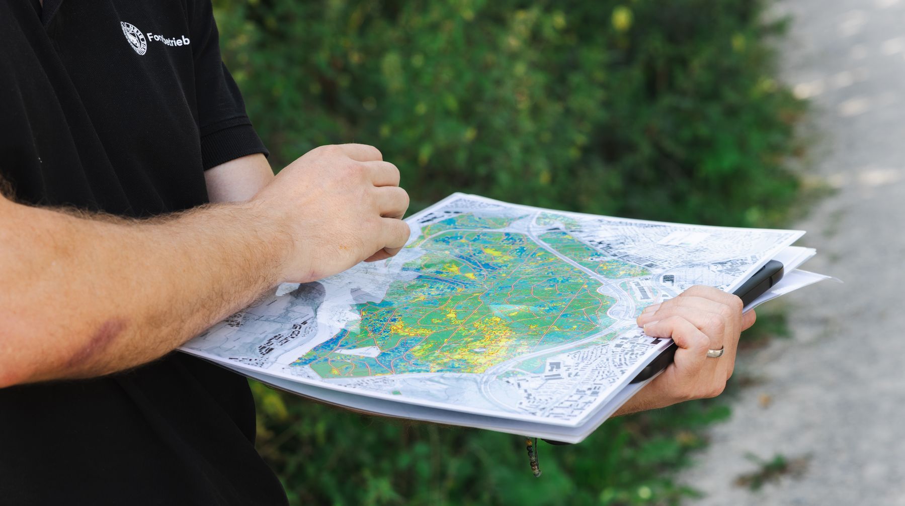 Zwei Hände, welche eine Karte des Waldes halten