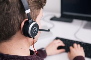 Eine Person am Computer mit Headset