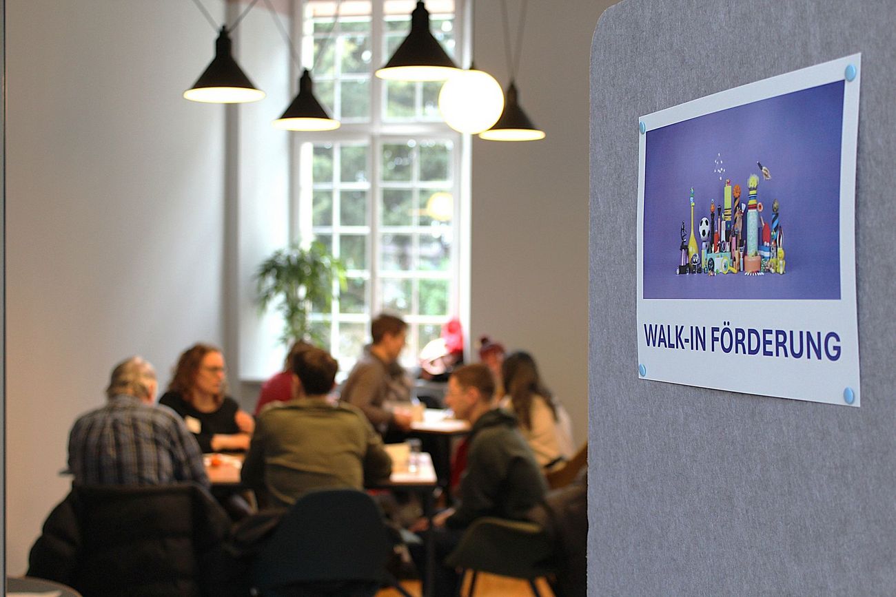 Viele Besuchende im Raum mit dem Beratungsangebot