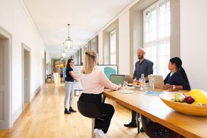 Mitarbeitende sitzen zusammen am Tisch für eine Besprechung