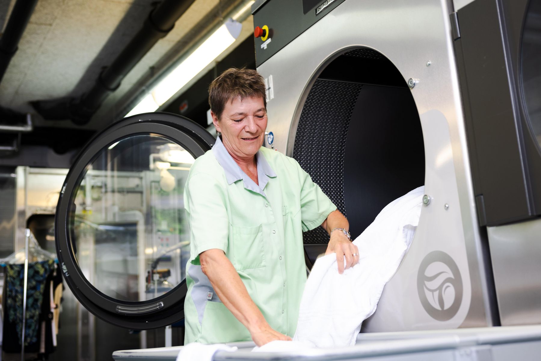 Frau, welche Wäsche aus der Waschmaschine nimmt